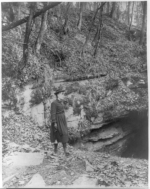 [Frances Benjamin Johnston, full, standing by wooded cliff at…, 1891