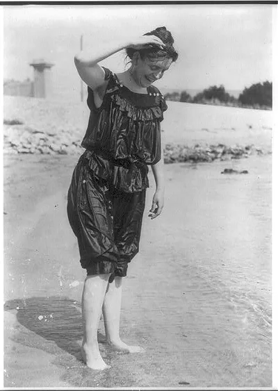 [Frances Benjamin Johnston, standing in surf in wet bathing suit]